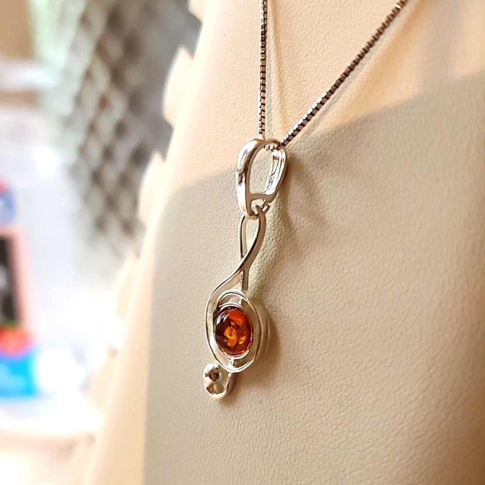 Amber pendant of the treble clef note